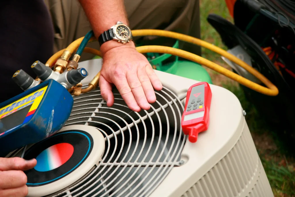 HVAC Maintenance in Poway, CA 1 A man checks the air conditioner using a tool, ensuring it operates efficiently.