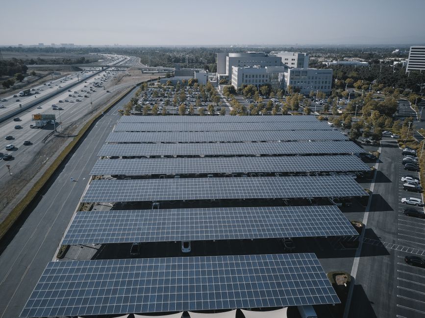 solar panels on residential rooftop charging electric vehicle with clear blue sky